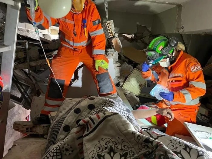 Deborah (right) treats a patient in the confined conditions of a collapsed building.