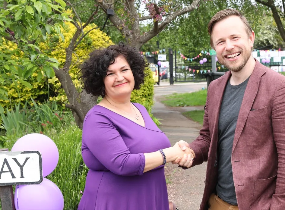 Headteacher Rachel Snape with Cllr Alex Beckett on problematic junction outside the school, posters in the background.