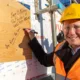 Anglian Ruskin University topping out ceremony for an extension to the Peterborough campus that will incorporate a ‘Living Lab’ public science and technology space. It will open in September. Principal Professor Ross Renton signs one of the roof panels. PHOTO: Terry Harris.